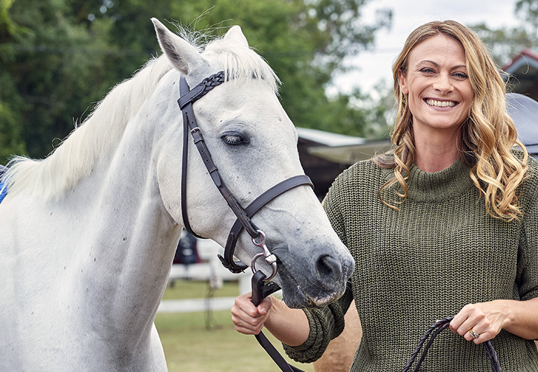 Headshot of Deb Wayman standing next to a horse